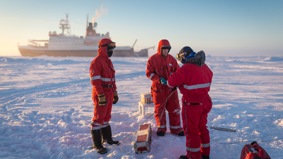 Wissenschaftler des deutschen Alfred-Wegener Institutes bereiten eine automatische Wetterstation auf dem arktischen Meereis vor.